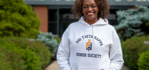 Chapter President Tammy Monroe standing before the Stark State College Campus entrance.